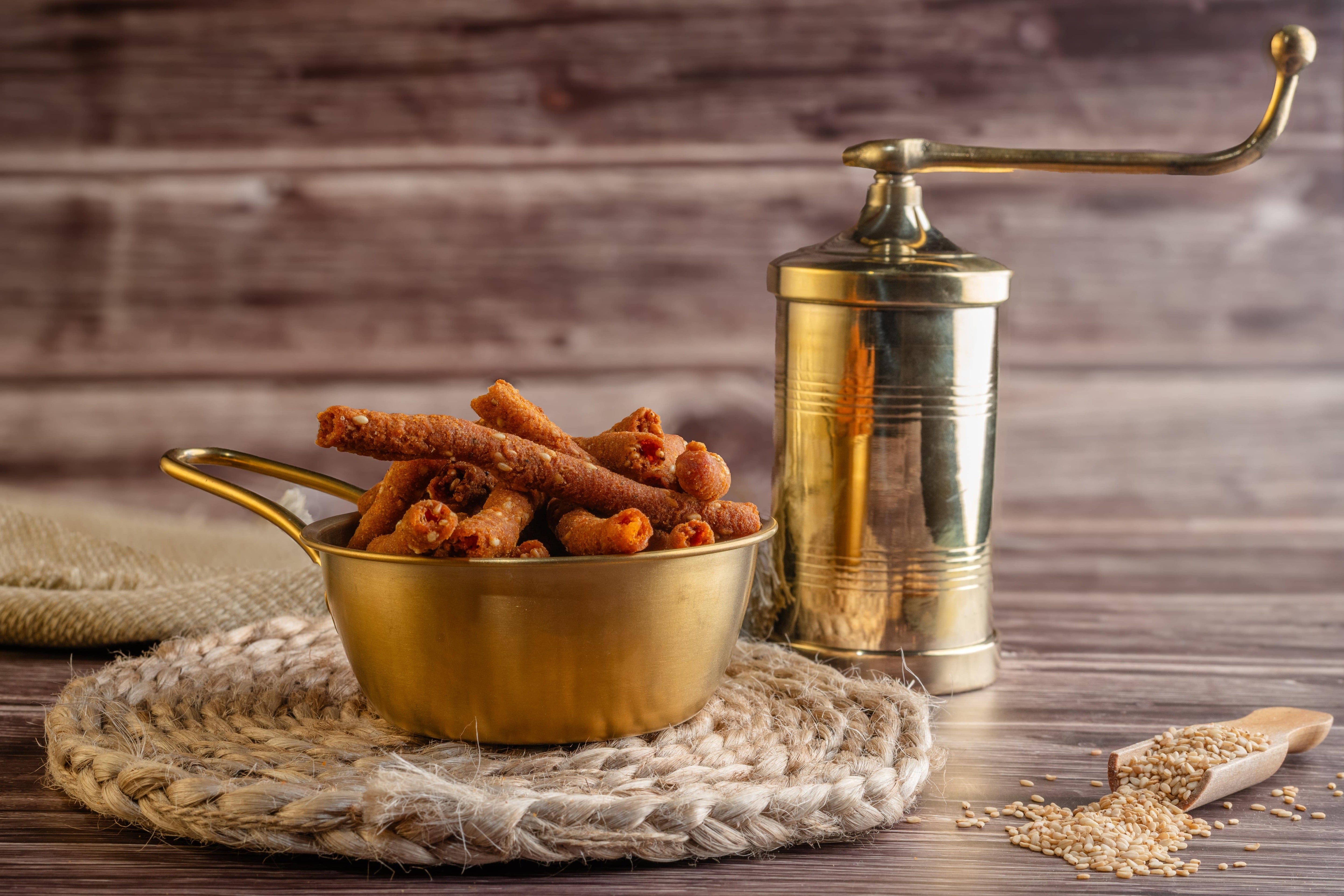 Buy Thil Muruk online from World of Mysore Pak. A crispy sesame snack seasoned with garlic, pepper, and a hint of chilli.